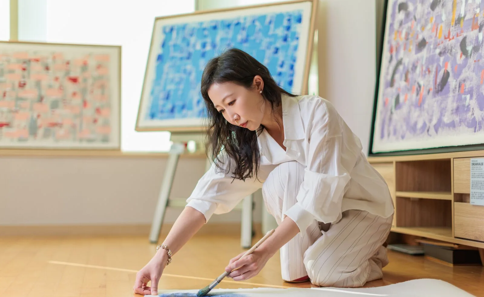 Eunju Park in her studio, among her paintings